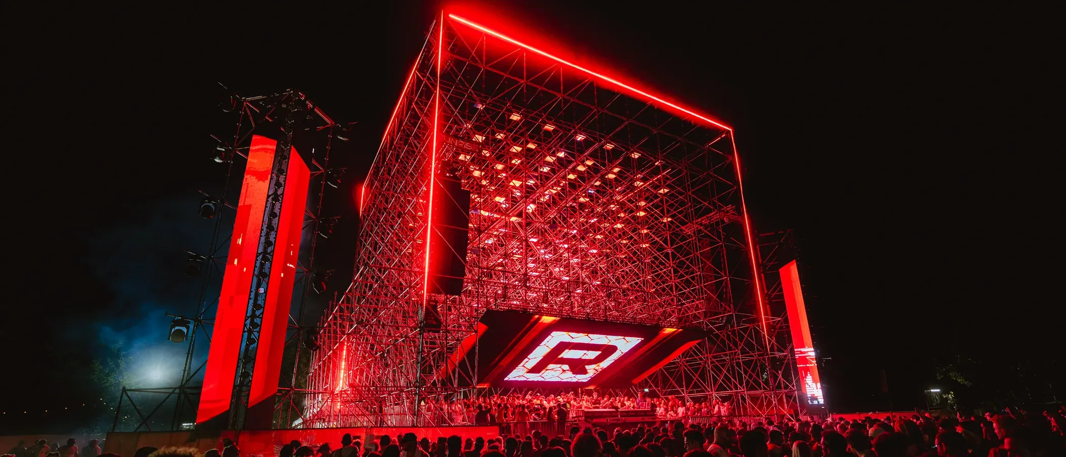 Isle of Summer Vienna 2026, Sunrise Stage on Donauinsel: 32 × 20 × 20 m lattice stage with the volumetric LED matrix lit at night, designed and operated by ØJE Studio